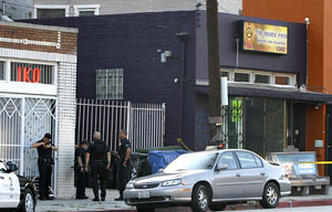 Photo: Officers gather at the shooting scene. Credit: John W. Adkisson / Los Angeles Times