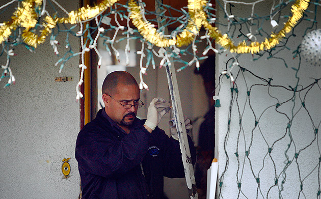Photo: An LAPD forensic investigator looks for evidence at a home in the 8700 block of McKinley Avenue in South Los Angeles, where LAPD officers fatally shot a suspect Sunday night. Credit: Jay L. Clendenin / Los Angeles Times