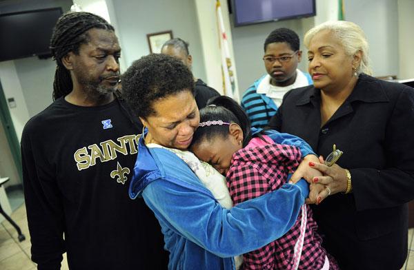 Photo: Cynthia Seymour hugs daughter Christian, 11, after the L.A. Police Department announced a $50,000 reward for information in the killing of Seymour's husband, Herbert Jr., who was shot Feb. 9. With them at the 77th Street Division Station are Herbert Seymour Sr. and Patricia Fargas. Credit: Wally Skalij / Los Angeles Times 