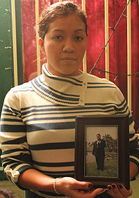 Photo: Paula Solis holds a picture of her brother Alfonso "Junior" Nava outside of the family home. Credit: Mary Slosson