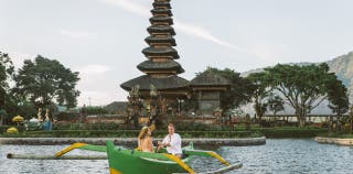 A man and woman riding in a boat in Bali.