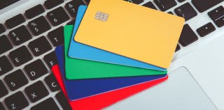 Five credit cards fanned out on a computer keyboard