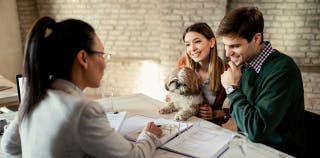 A couple viewing pet insurance coverage options with their dog