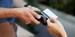 A person using the Delta Platinum card on a card machine