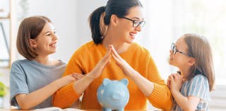 A woman with a piggy bank speaking to two children about savings accounts