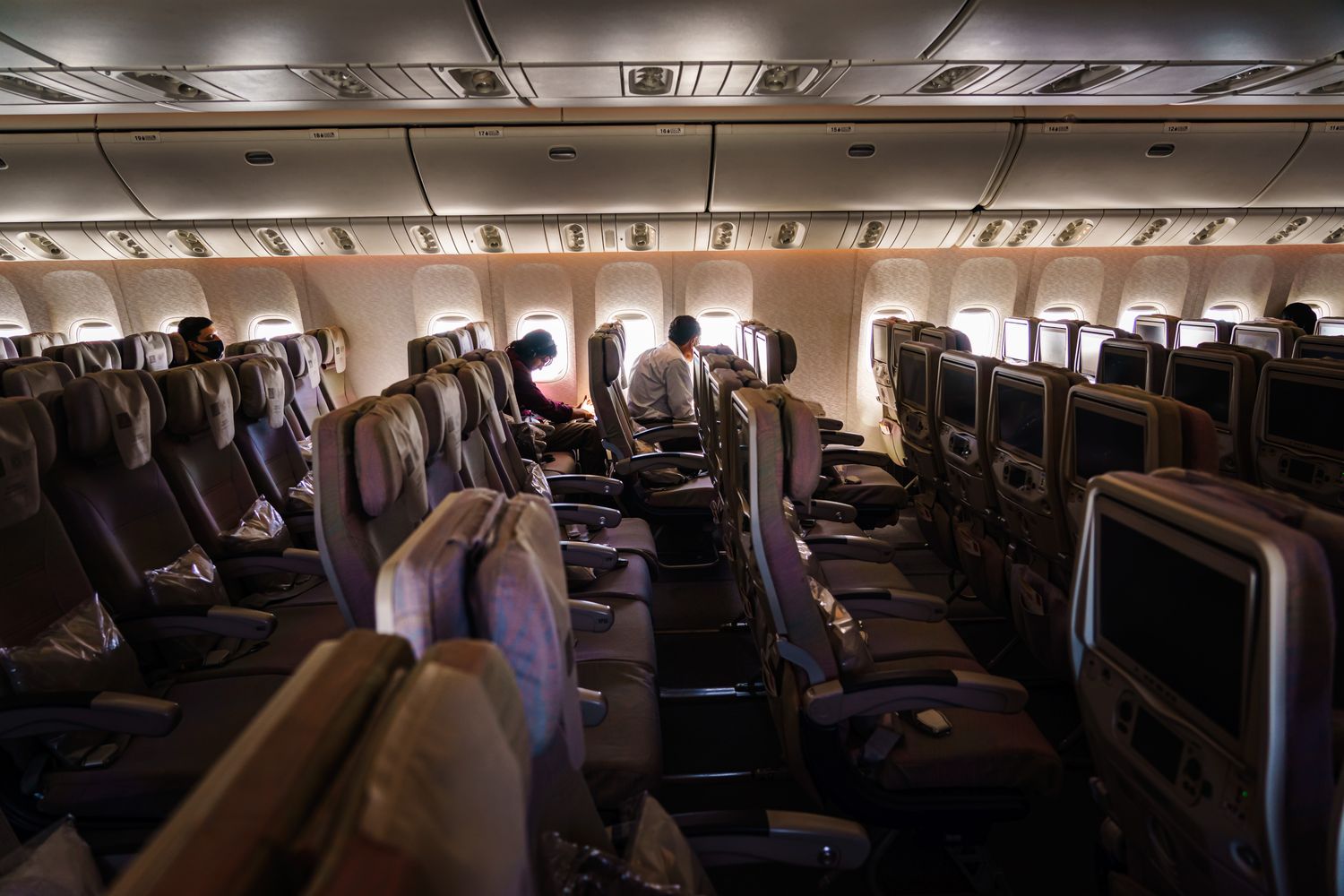 The inside of a commercial airplane with majority empty seats.