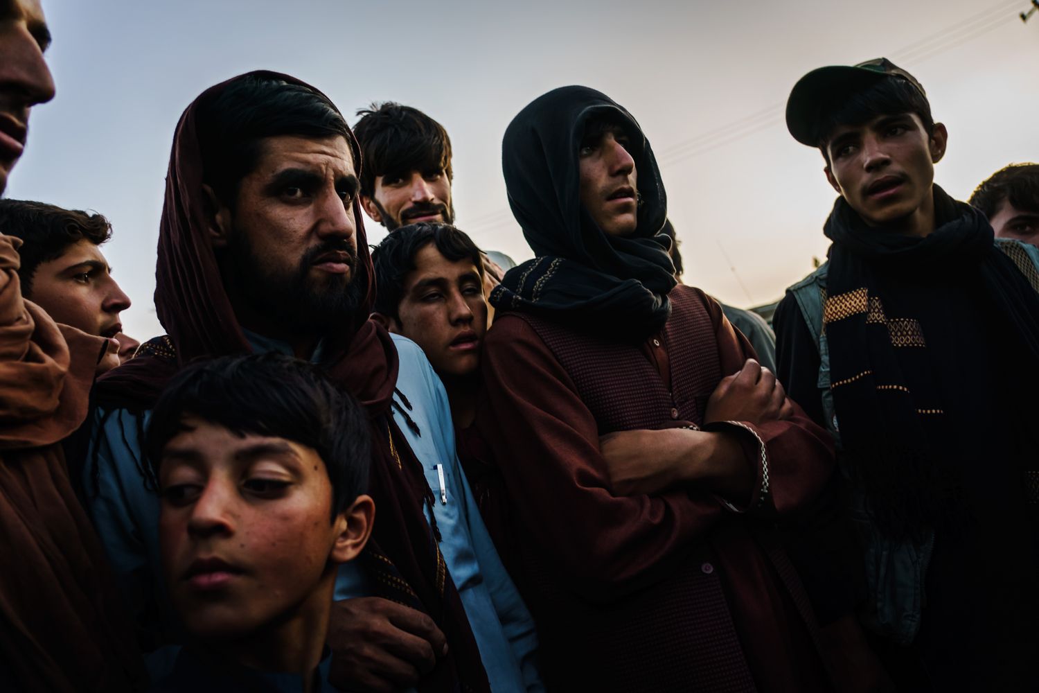 A group of men and boys together standing outdoors.