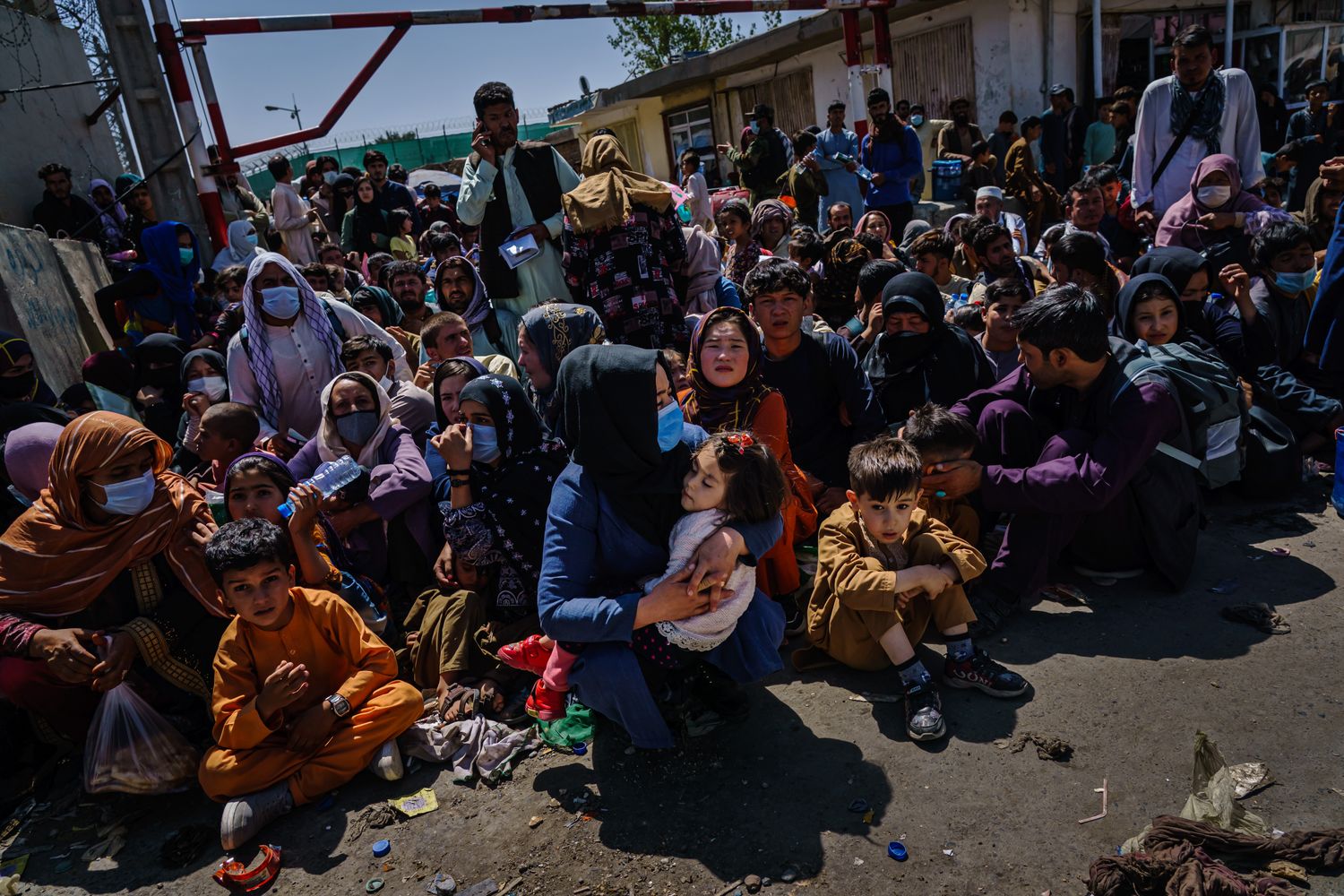 A throng of women and children seated in a street.
