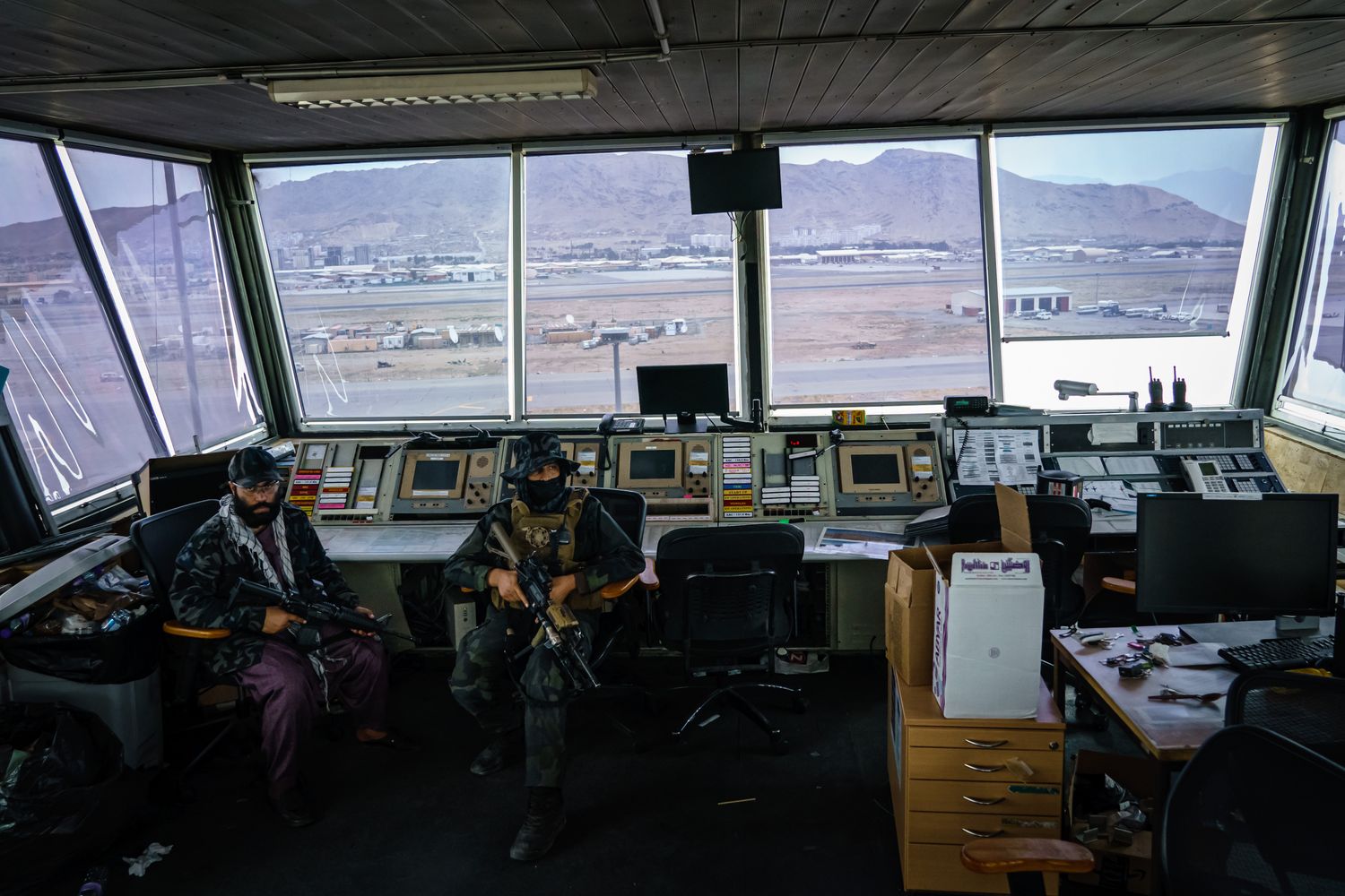 Two Taliban fighters sit in an air traffic control tower.