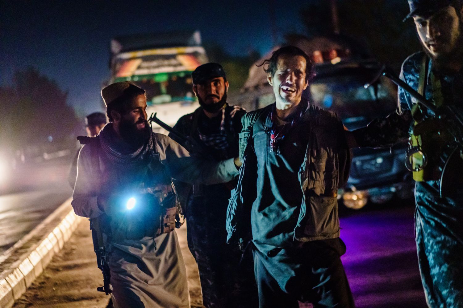 A man cries as he is arrested by three Taliban officers.