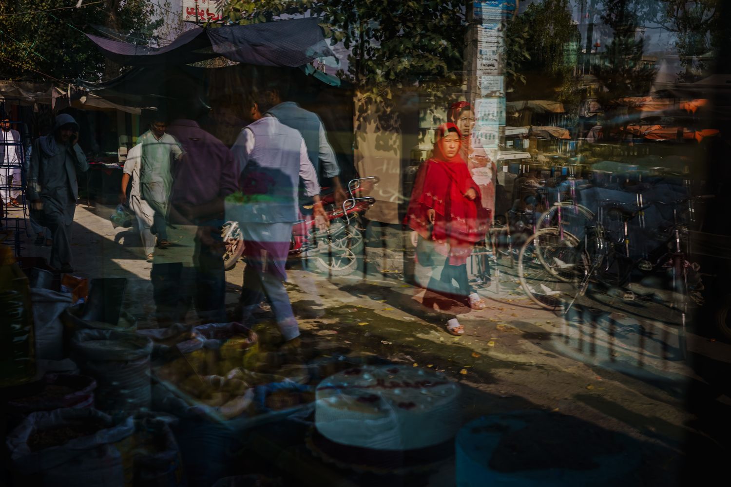 A double exposure of people walking along a market street.