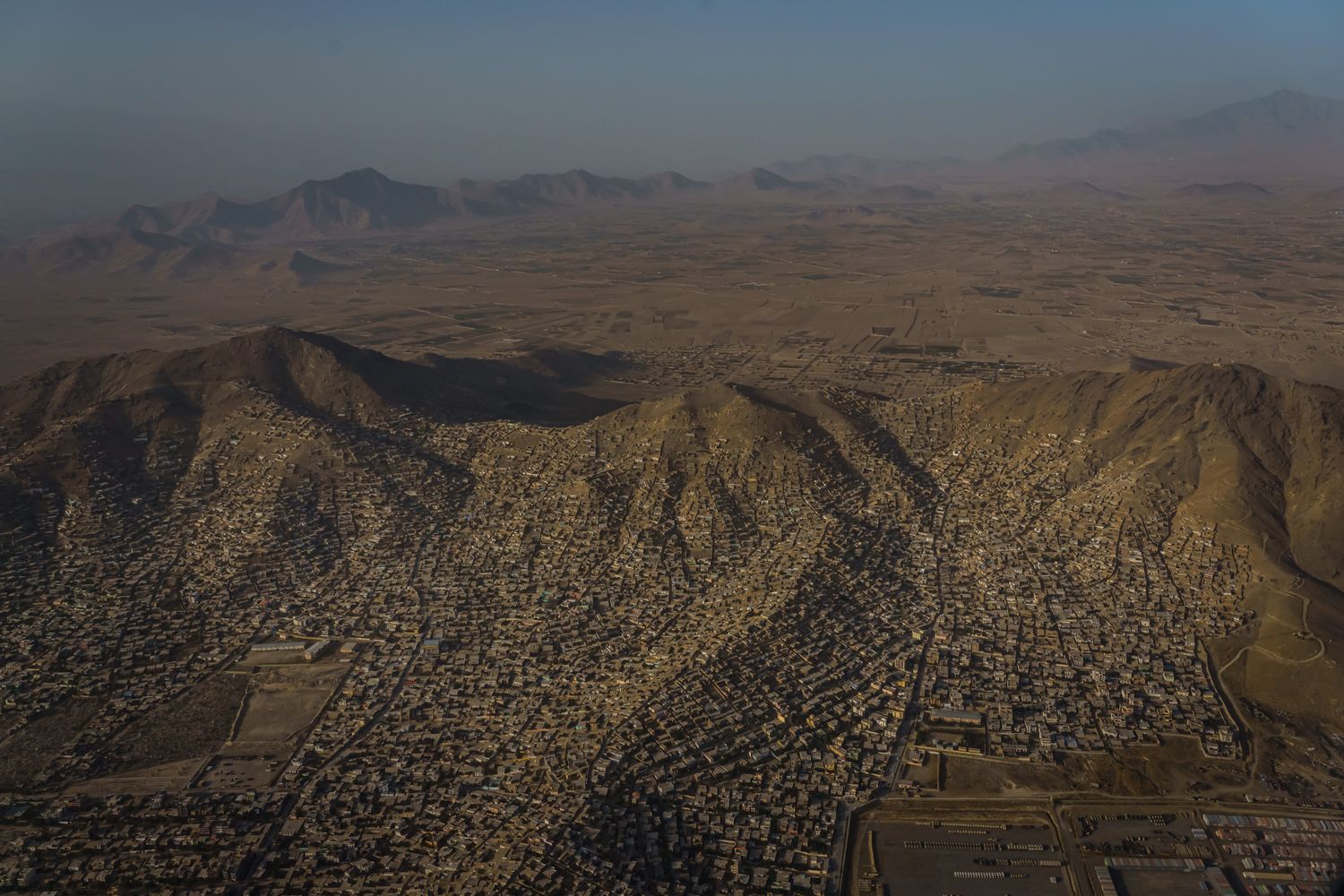 An aerial view of the city of Kabul seen from an airplane window.