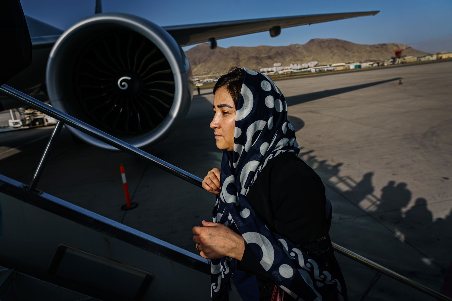 A woman climbs the steps to board a plane.