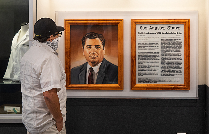 Former Los Angeles Times reporter Robert Lopez looking at a painting of Ruben Salazar at Cal State LA