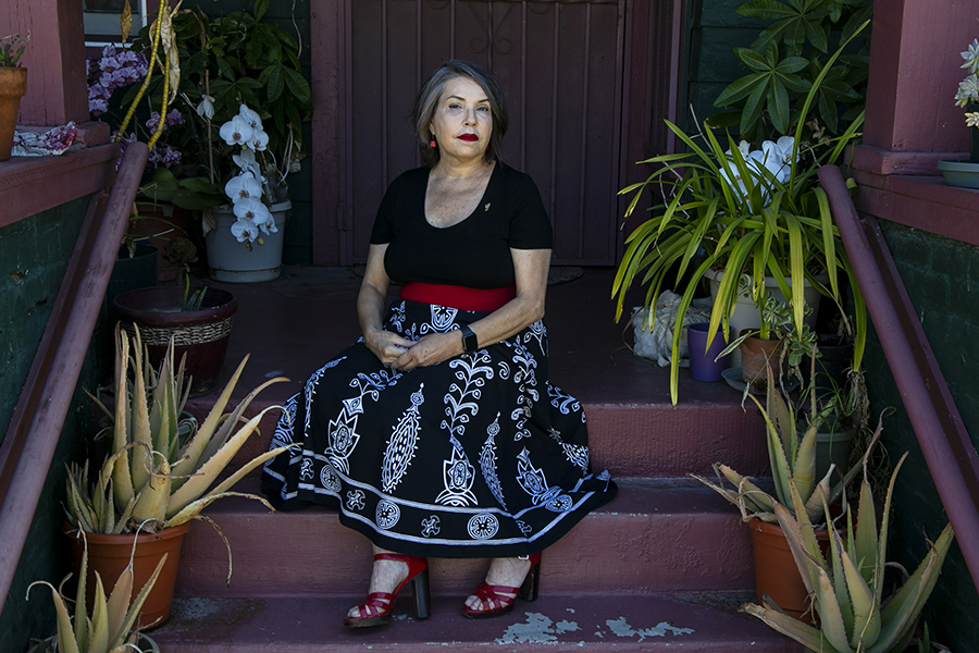 Consuelo Flores sits on the steps of her West Adams district home.