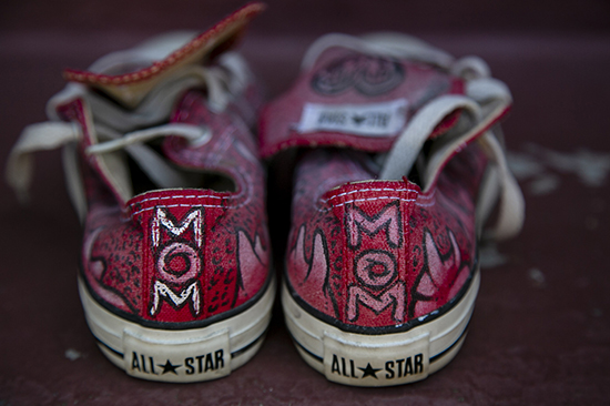 A pair of Consuelo Flores red shoes painted by her son say Mom