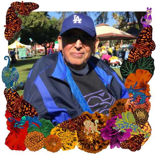 Photo of Alfonso Corral in a frame with marigolds, flowers, alebrijes and monarch butterflies.