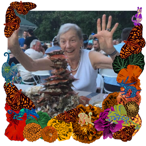 Photo of Barbara P Willis in a frame with marigolds, flowers, alebrijes and monarch butterflies.