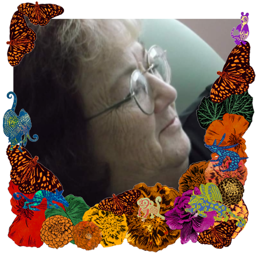 Photo of Grandma Betty "Jonnie" in a frame with marigolds, flowers, alebrijes and monarch butterflies.