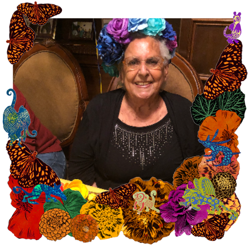 Photo of Consuelo Guerra in a frame with marigolds, flowers, alebrijes and monarch butterflies.