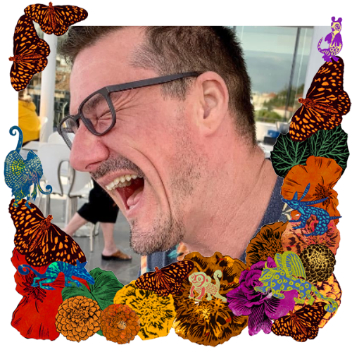 Photo of Eric Mueller in a frame with marigolds, flowers, alebrijes and monarch butterflies.