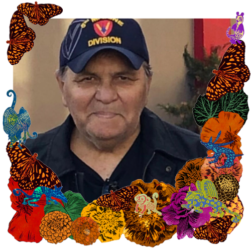 Photo of Gustavo Campos in a frame with marigolds, flowers, alebrijes and monarch butterflies.