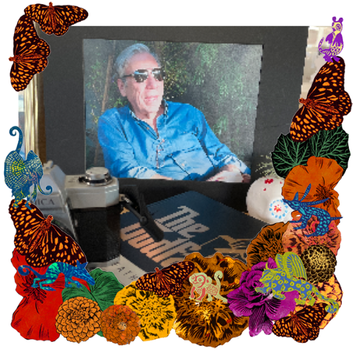 Photo of Joe Russo in a frame with marigolds, flowers, alebrijes and monarch butterflies.