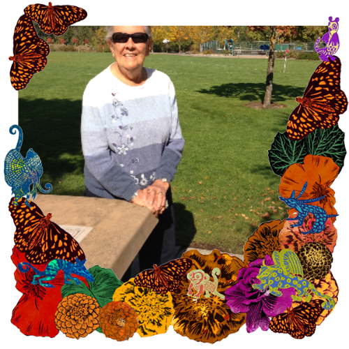 Photo of Marion Standlea in a frame with marigolds, flowers, alebrijes and monarch butterflies.