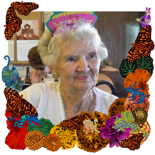Photo of My mom in a frame with marigolds, flowers, alebrijes and monarch butterflies.