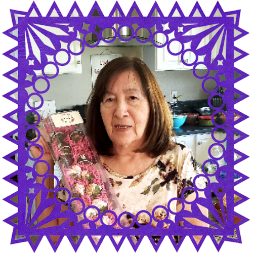 Photo of My mom in a frame with papel picado.