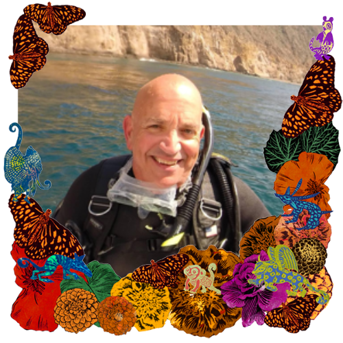 Photo of Skip Tucker in a frame with marigolds, flowers, alebrijes and monarch butterflies.