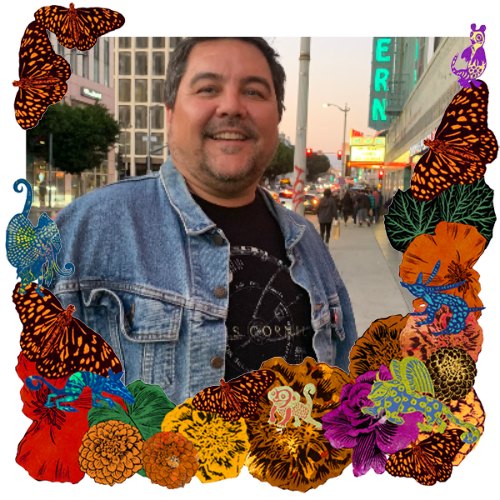 Photo of Steve Aragon in a frame with marigolds, flowers, alebrijes and monarch butterflies.
