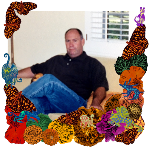 Photo of Tim Fabian in a frame with marigolds, flowers, alebrijes and monarch butterflies.