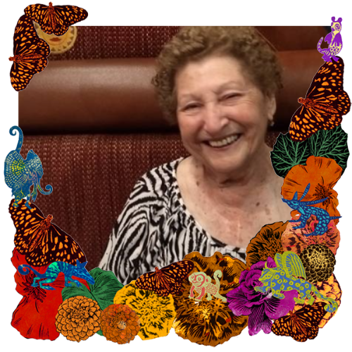 Photo of Victoria Munro de Williams in a frame with marigolds, flowers, alebrijes and monarch butterflies.