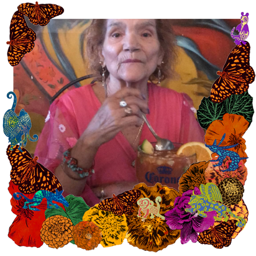 Photo of My mother/ Mi amá in a frame with marigolds, flowers, alebrijes and monarch butterflies.