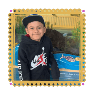Foto de Sobrino adentro de un borde de papel picado amarillo con puntos rosas en las esquinas
