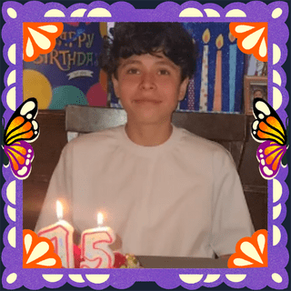 Photo of George in an illustrated frame of purple papel picado, with monarch butterfly wings.