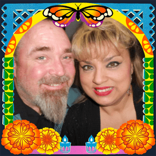 Photo of Adam and Marie Gracie in an illustrated frame of blue and green papel picado, with a monarch butterfly, marigold flowers and candles.