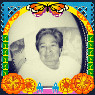 Photo of Maria R. Lopez in an illustrated frame of blue and green papel picado, with a monarch butterfly, marigold flowers and candles.