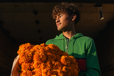 A young flower market worker unloading a fresh cempasúchil truckload.