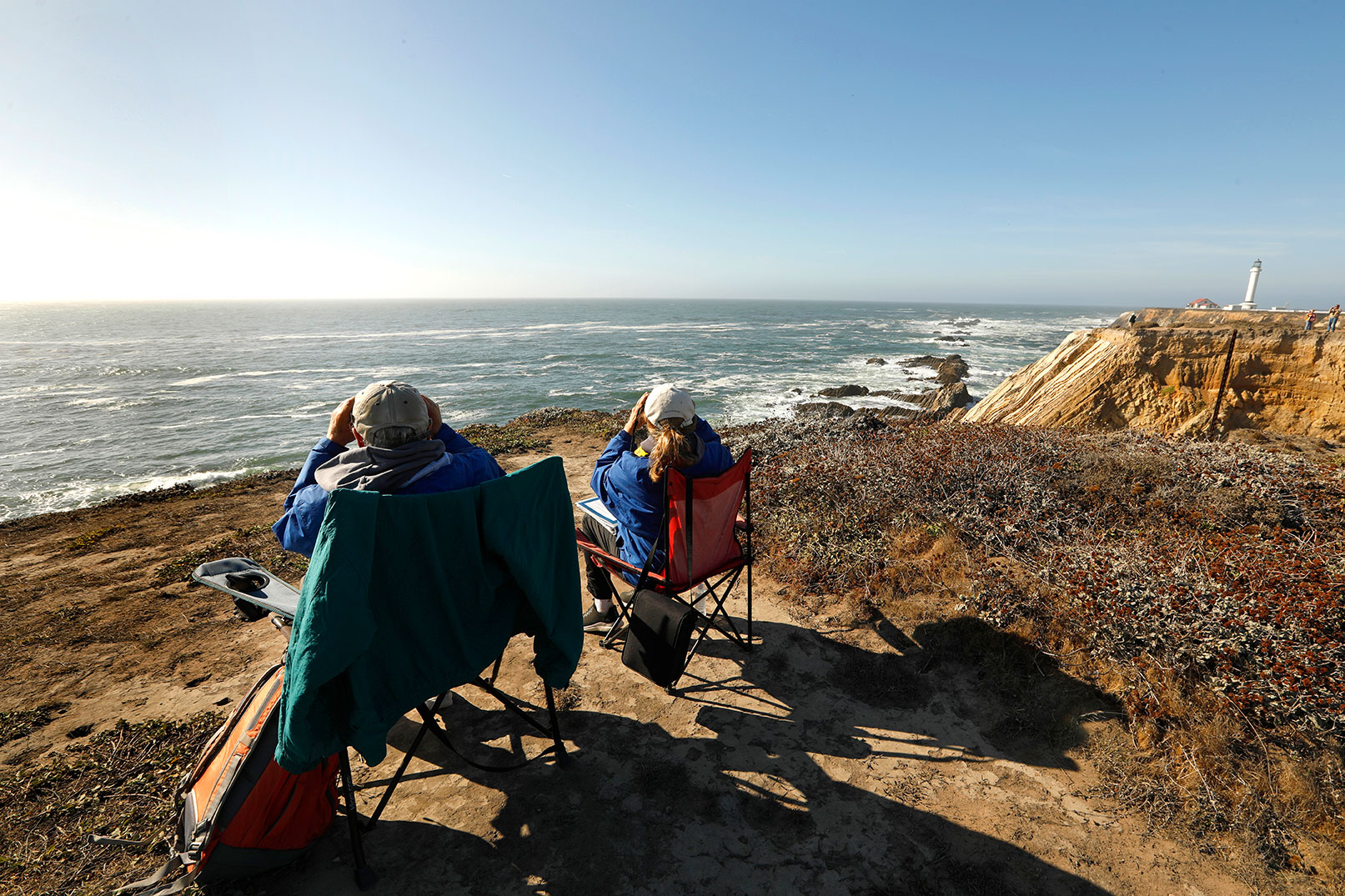 Scott Mercer, left, a whale biologist in New England, relocated to the Pacific Coast with his wife, Tree Mercer, right. During the pandemic, they spent nearly every day monitoring whales and recording data from a bluff near Point Arena Lighthouse in Mendocino County.