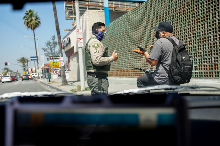 L.A. County Sheriff’s Deputy Manan Butt advises Ubaldo Delacruz that he can’t ride on the sidewalk in East Los Angeles. Delacruz, who has been stopped at least three times in the last four years, was let go with a warning.