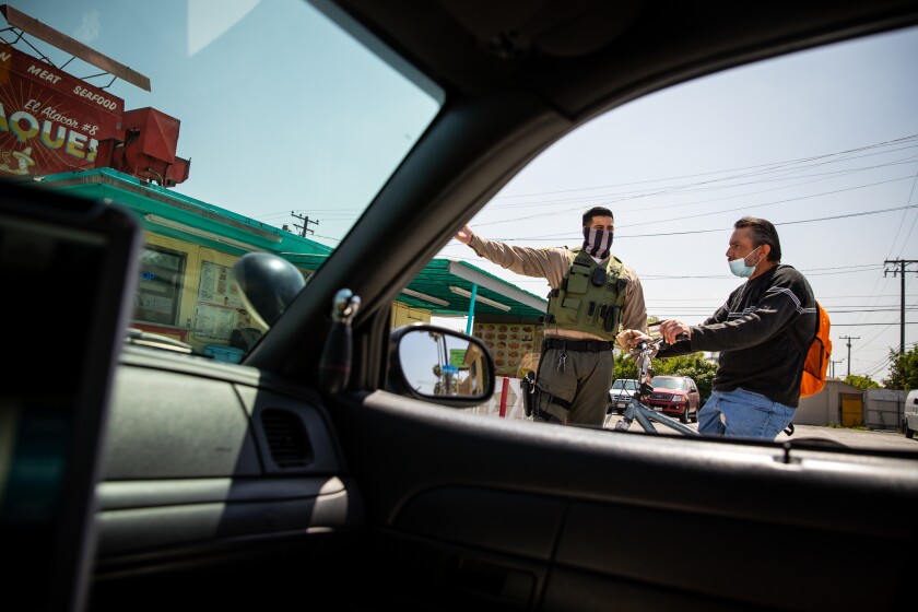 Los Angeles County Sheriff’s Deputy Manan Butt warns Sirilo Villalpando that he’s not allowed to ride his bike on the sidewalk in East L.A.