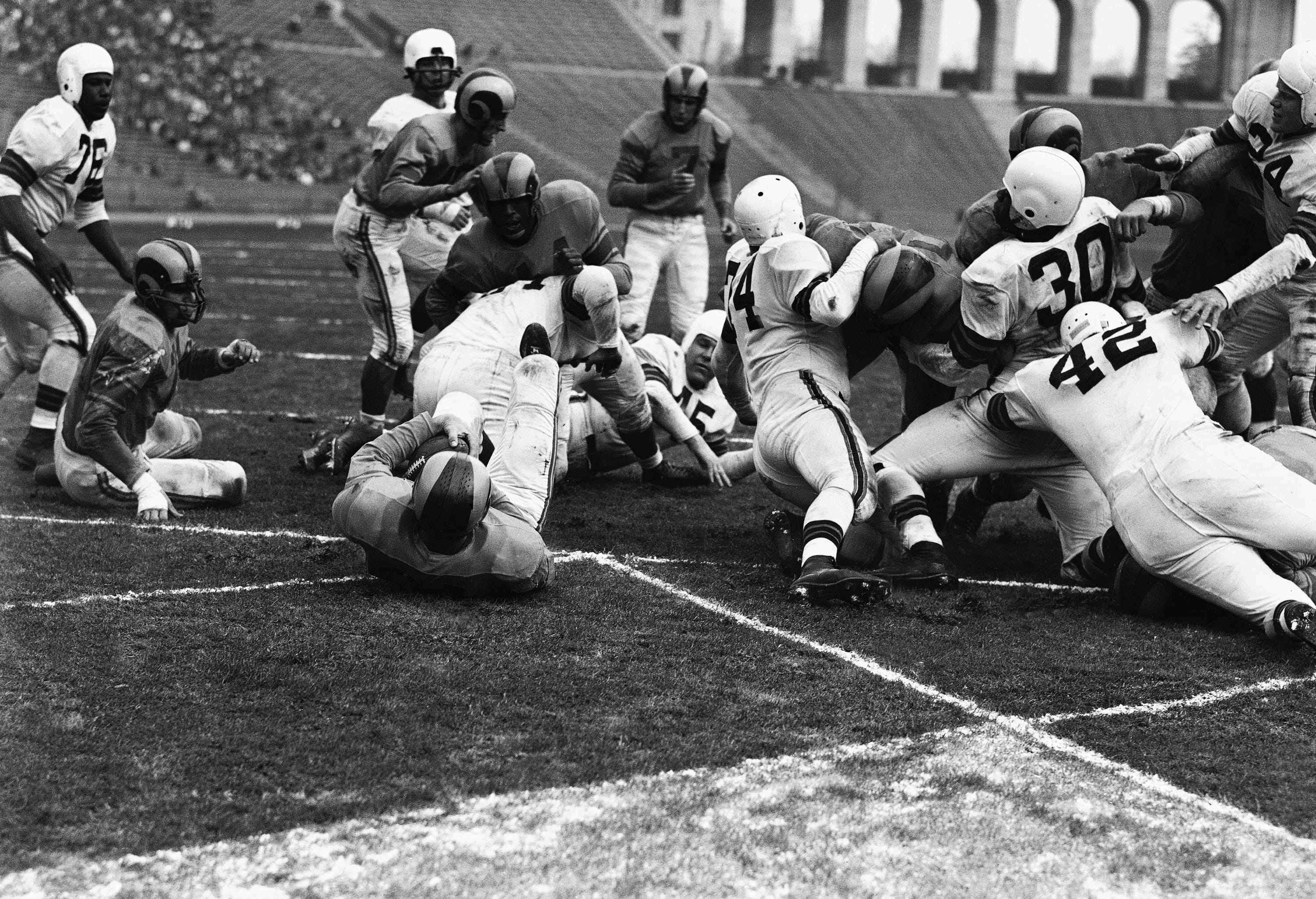 Los Angeles Rams fullback Dick Hoerner lands on his back in the end zone to score a touchdown against the Cleveland Browns in the 1951 NFL championship game at the Coliseum.