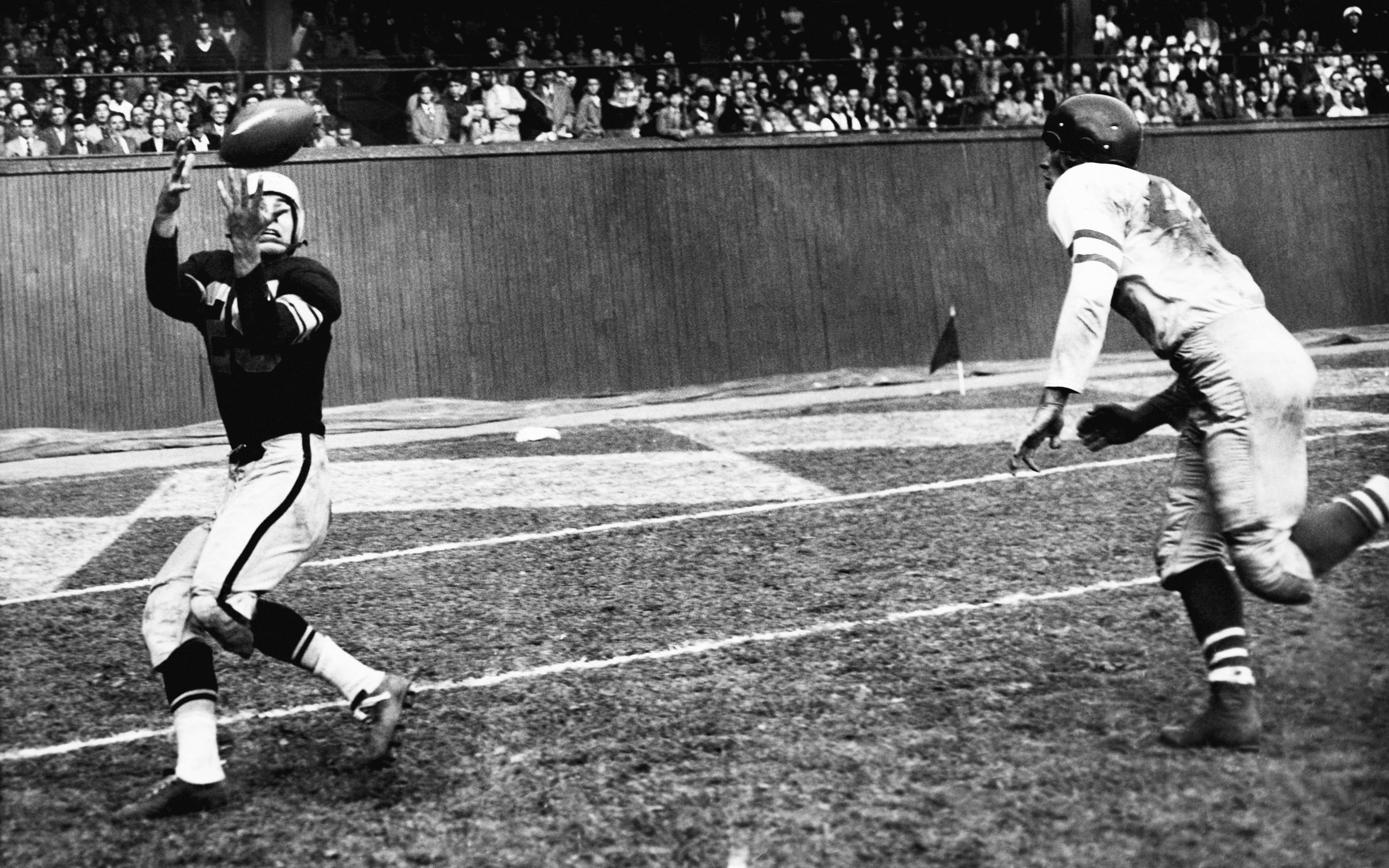 Pittsburgh Steelers halfback Ray Matthews catches a touchdown pass ahead of Philadelphia's Bob Stringer during a game in October 1952.