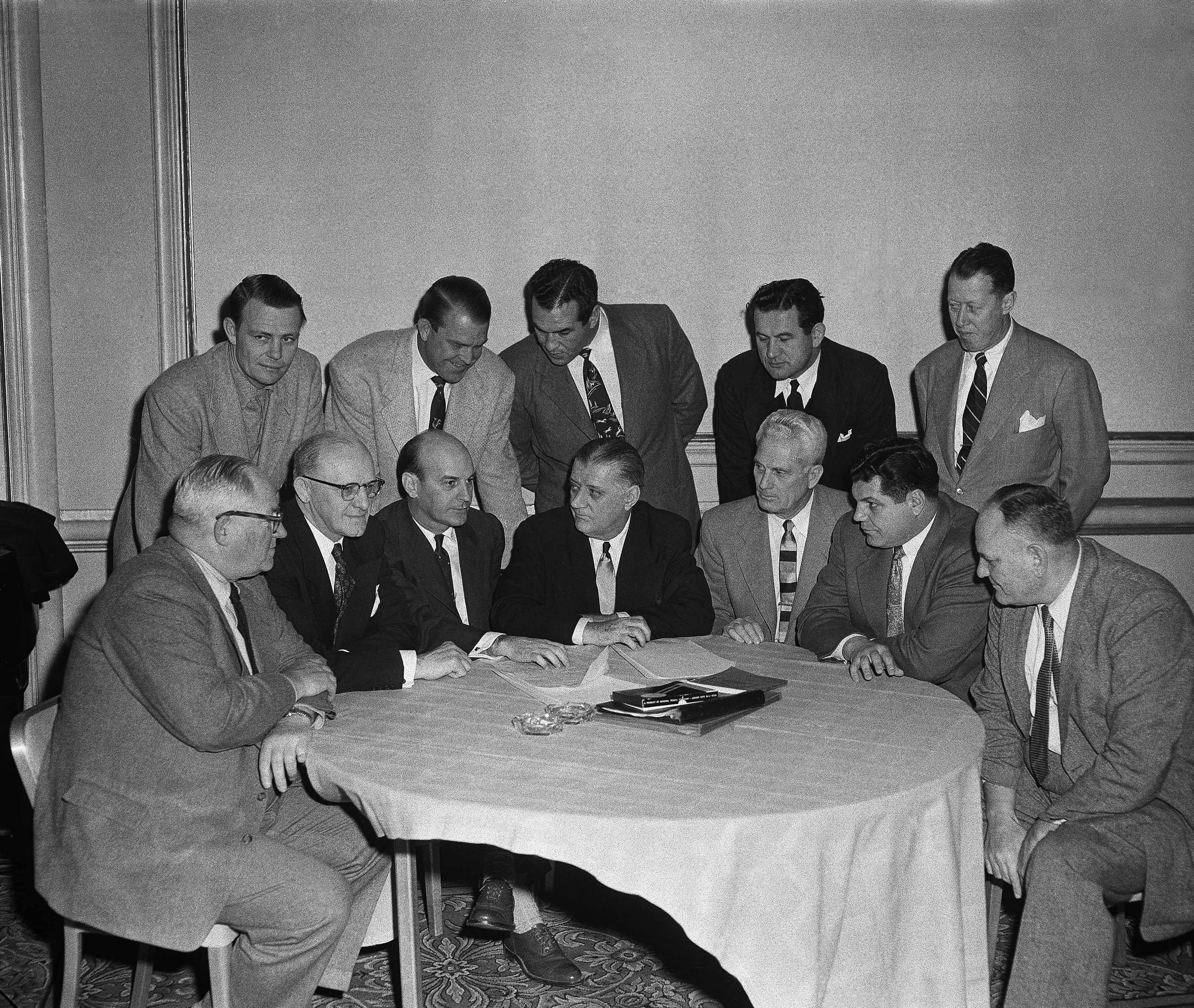 NFL commissioner Bert Bell, seated at the middle, speaks with owners and representatives from teams during a league meeting in Philadelphia in January 1953.