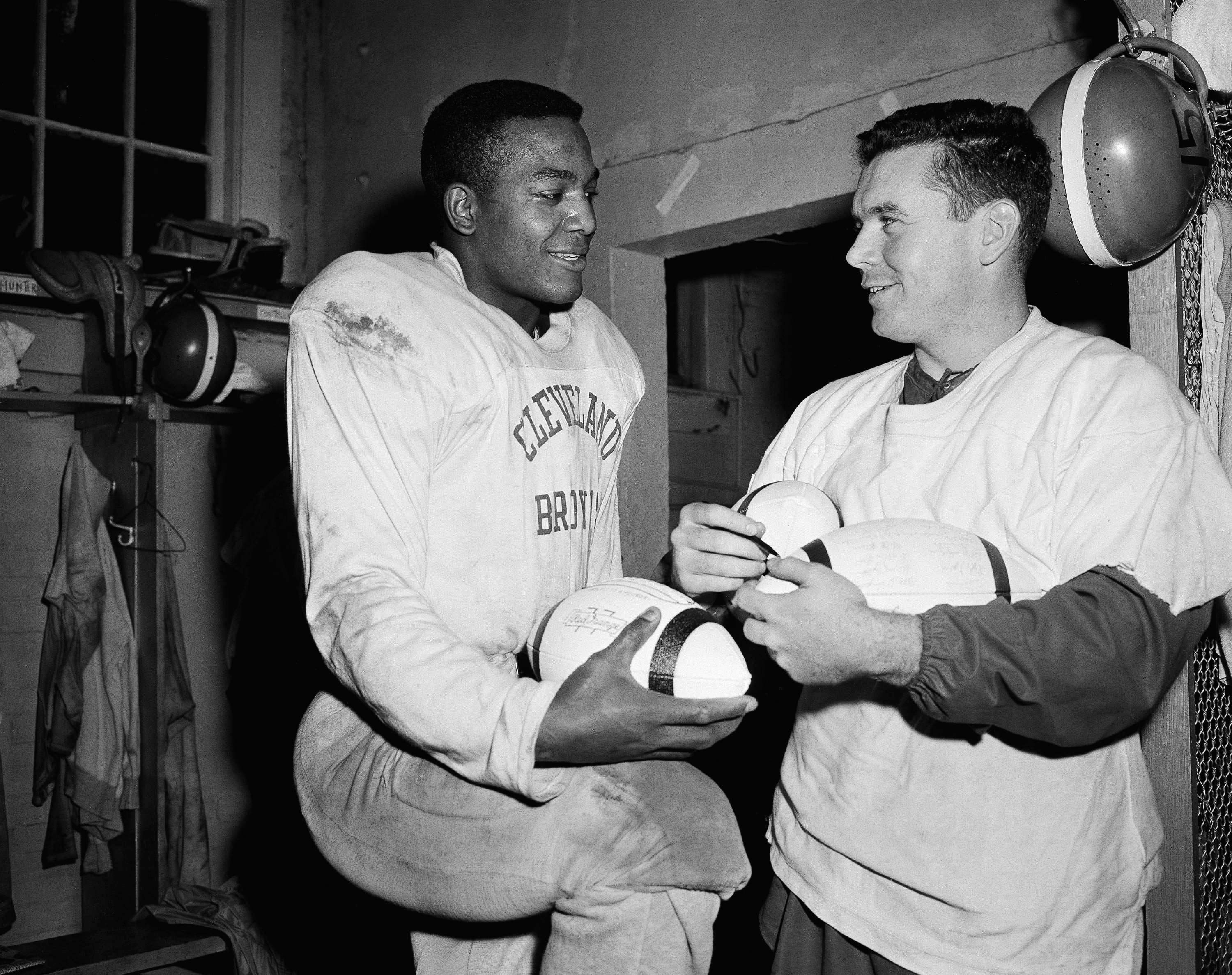 Cleveland Browns fullback Jim Brown, left, speaks with quarterback Tommy O'Connell in 1957.