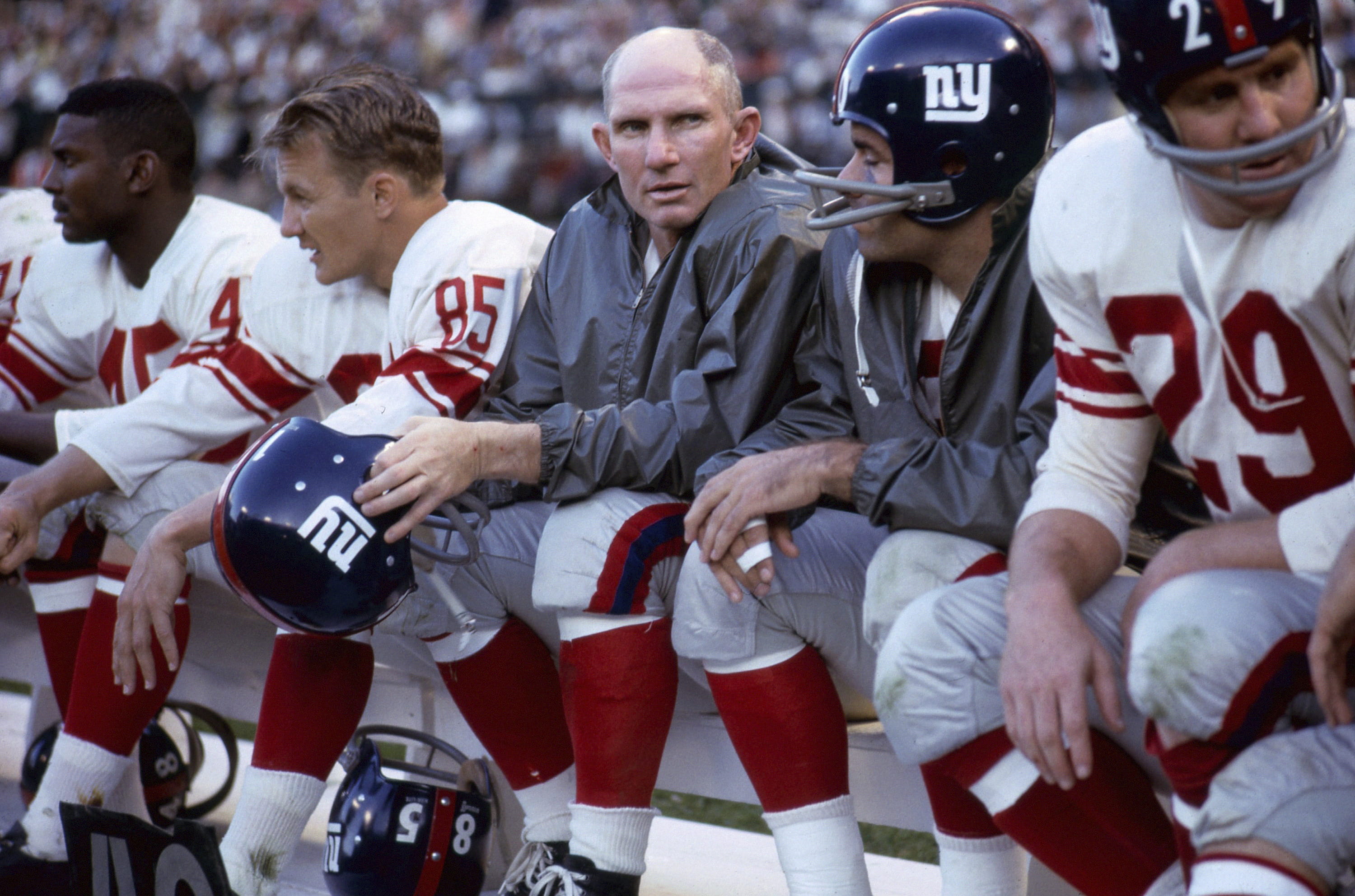 New York Giants quarterback Y.A. Tittle, center, sits on the bench with his teammates during a game in 1964.