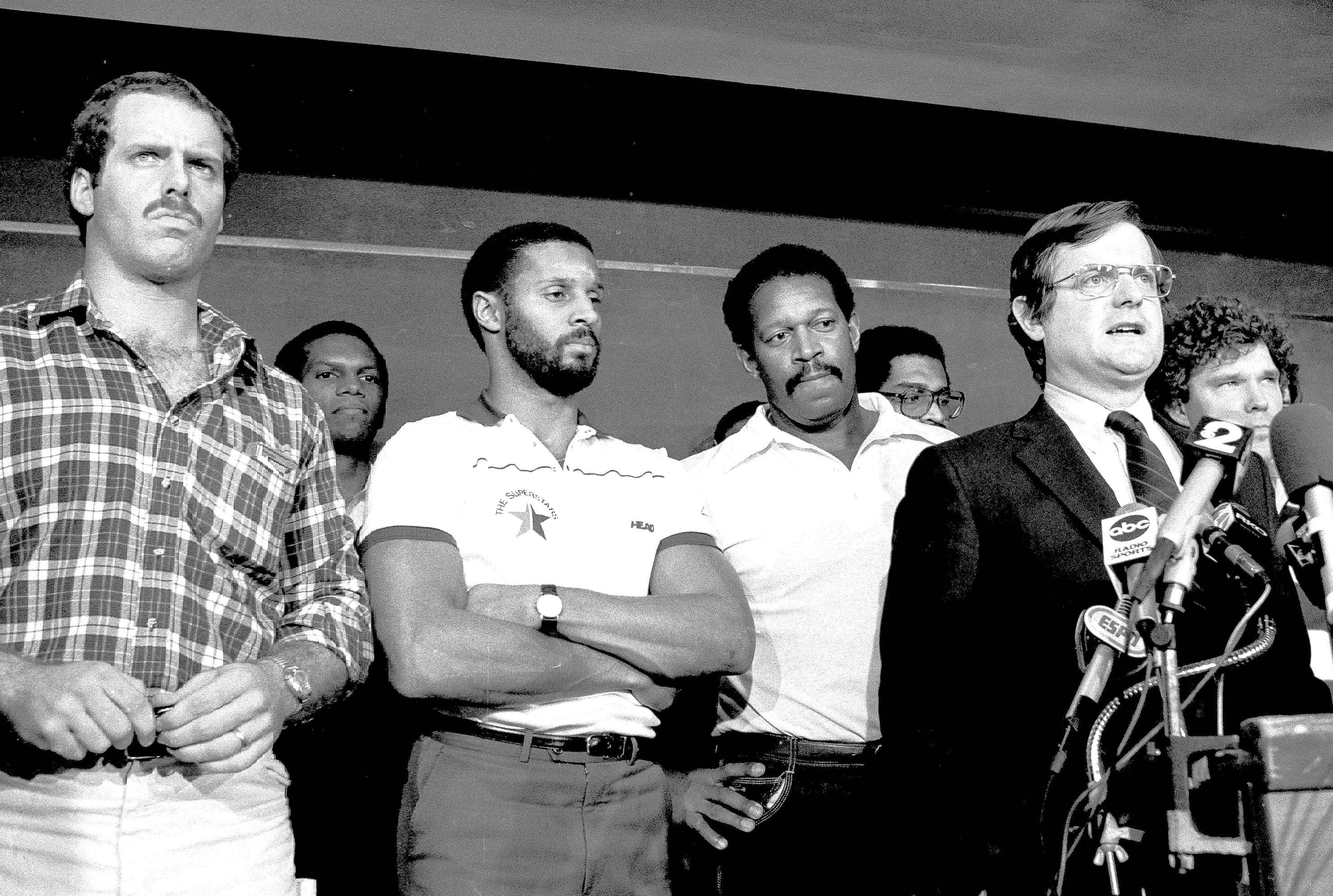 Ed Garvey, the chief negotiator for the NFL players' union, stands in front of players while speaking at a news conference in November 1982.