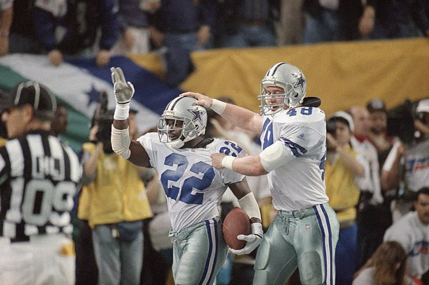 Dallas Cowboys running back Emmitt Smith (22) is congratulated by teammate Daryl Johnston after scoring a touchdown during a win over the Buffalo Bills in Super Bowl XXVIII.